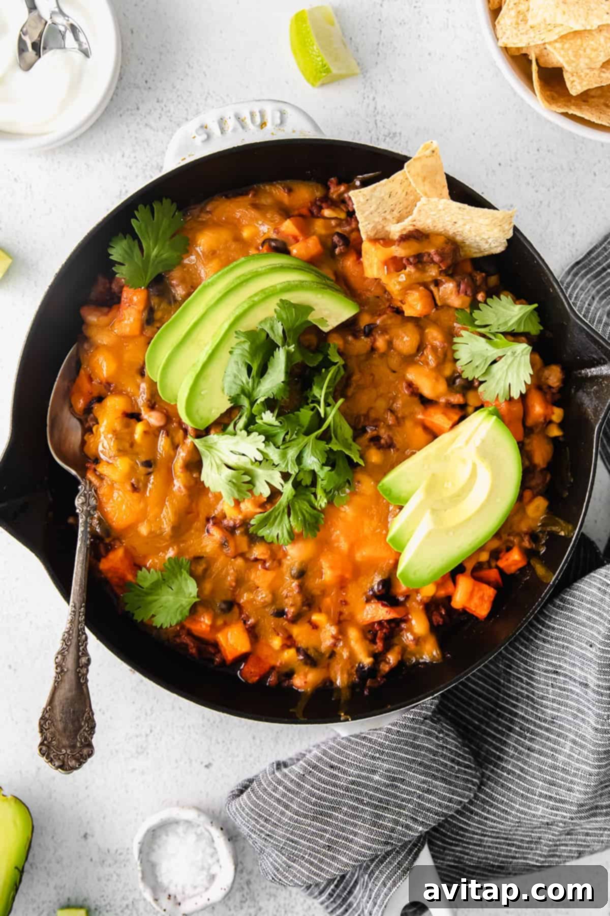 Delicious Turkey Sweet Potato Enchilada Skillet topped with fresh avocado slices and vibrant cilantro, ready to be served.