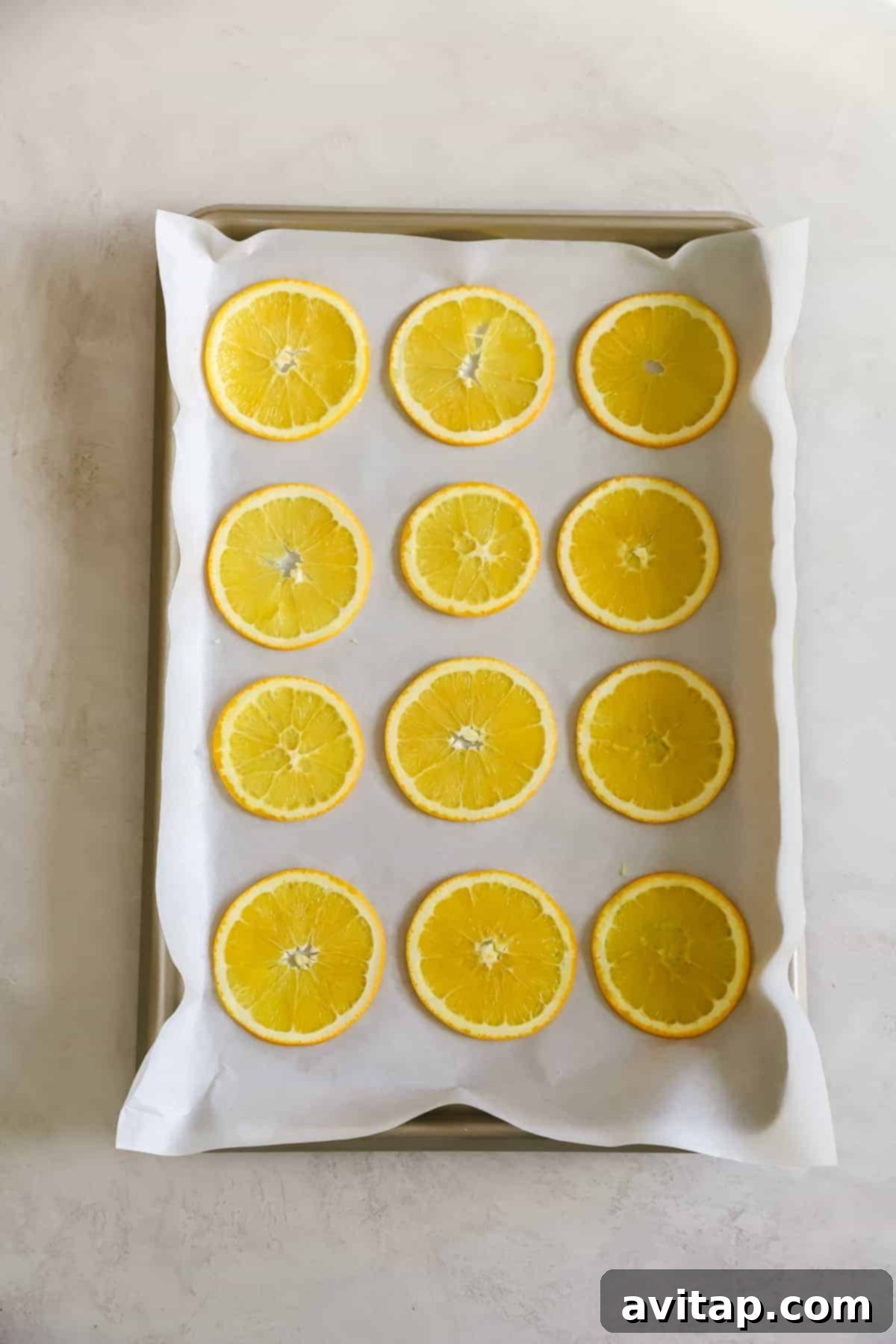 Perfectly arranged orange slices on a baking sheet for holiday garland Oranges arranged on a baking sheet, ready for drying