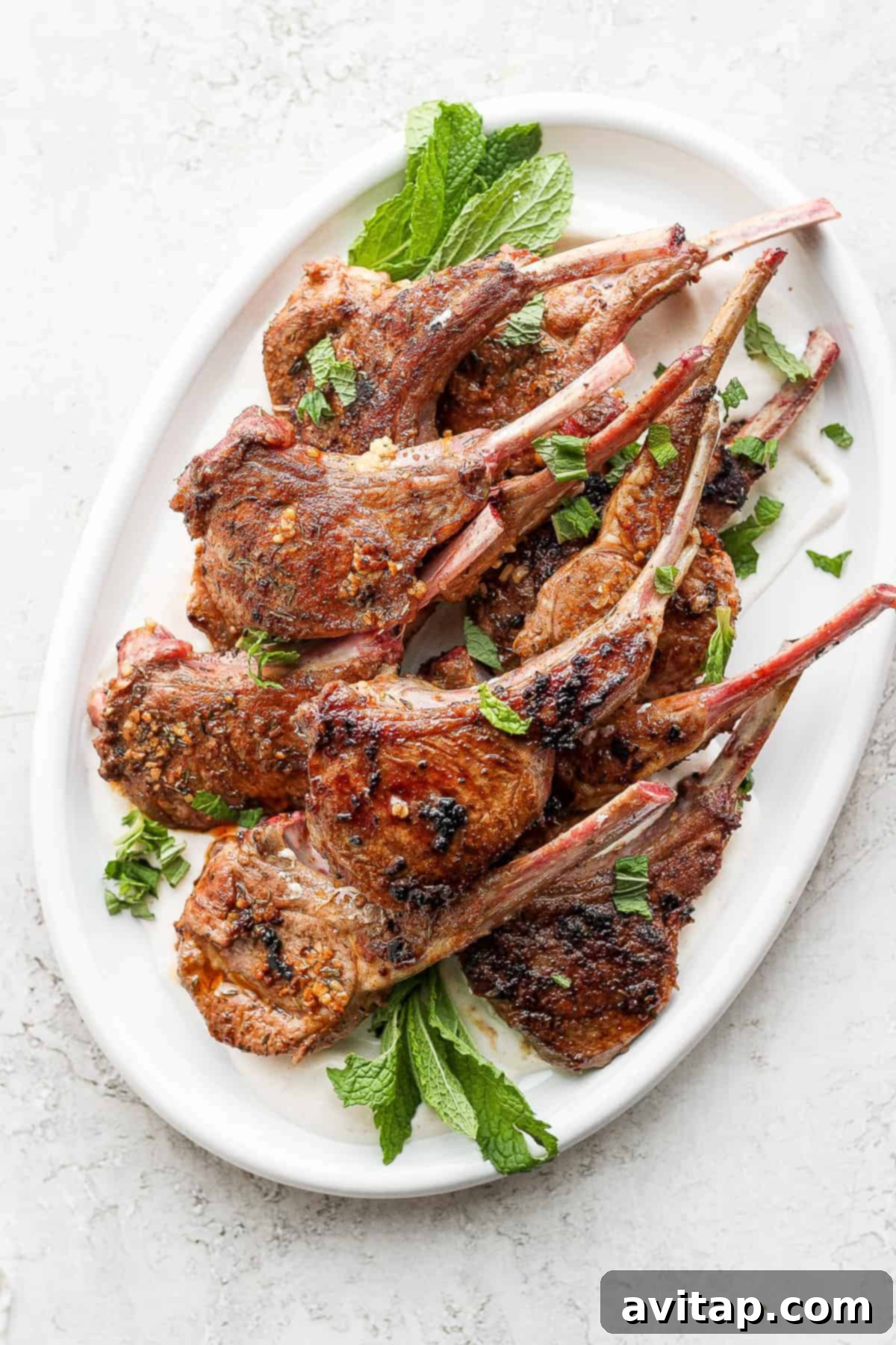 pan seared lamb chops on a plate garnished with fresh mint