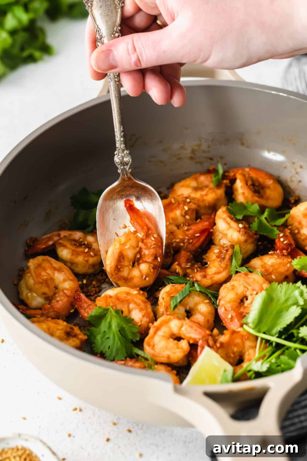 Garlic Butter Shrimp 8 Sautéed shrimp garnished with fresh herbs and sesame seeds in a bowl.