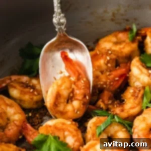 Garlic Butter Shrimp 10 Cooked shrimp on a spoon, ready to be served.