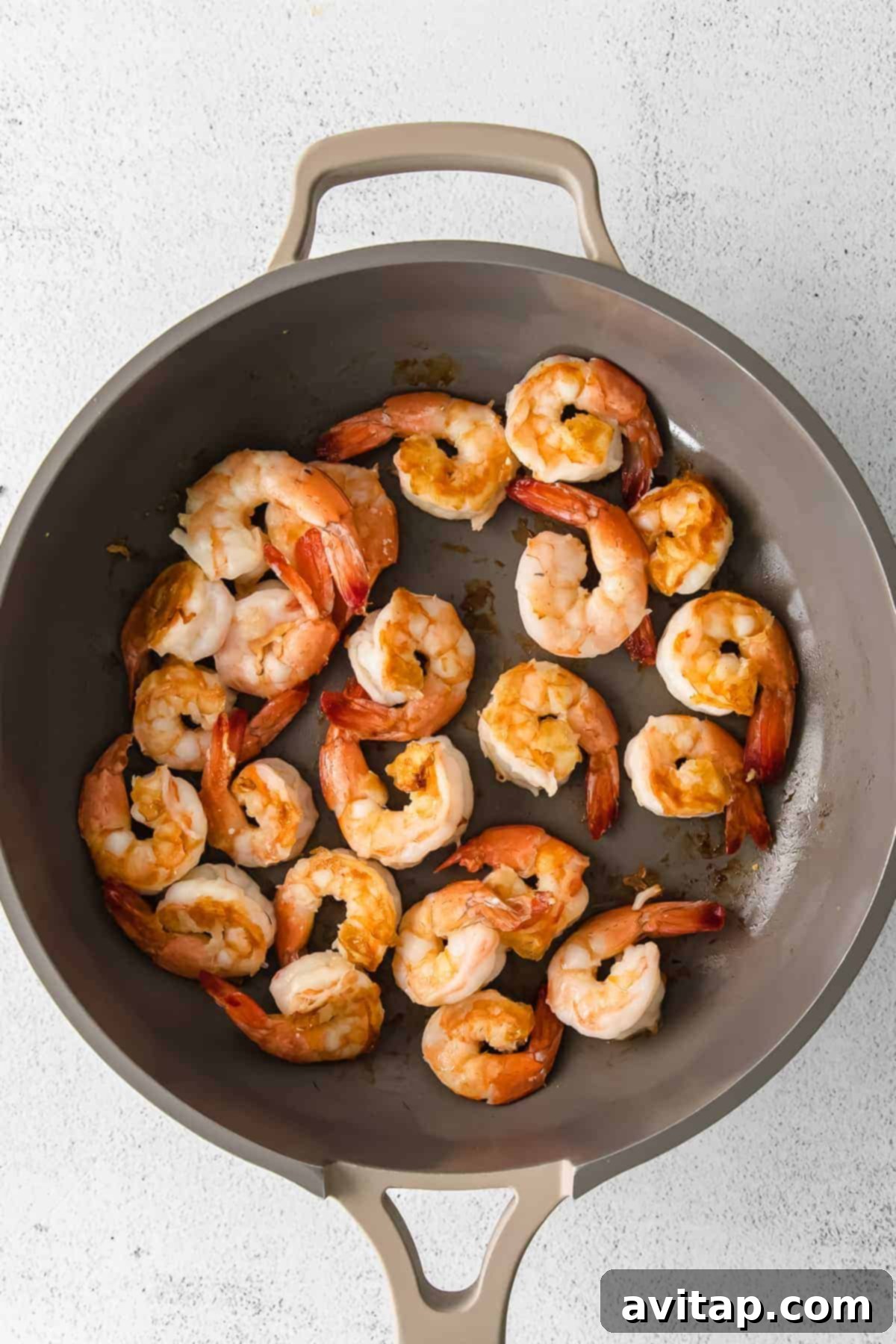 Garlic Butter Shrimp 5 Close-up of cooked shrimp in a pan with herbs.