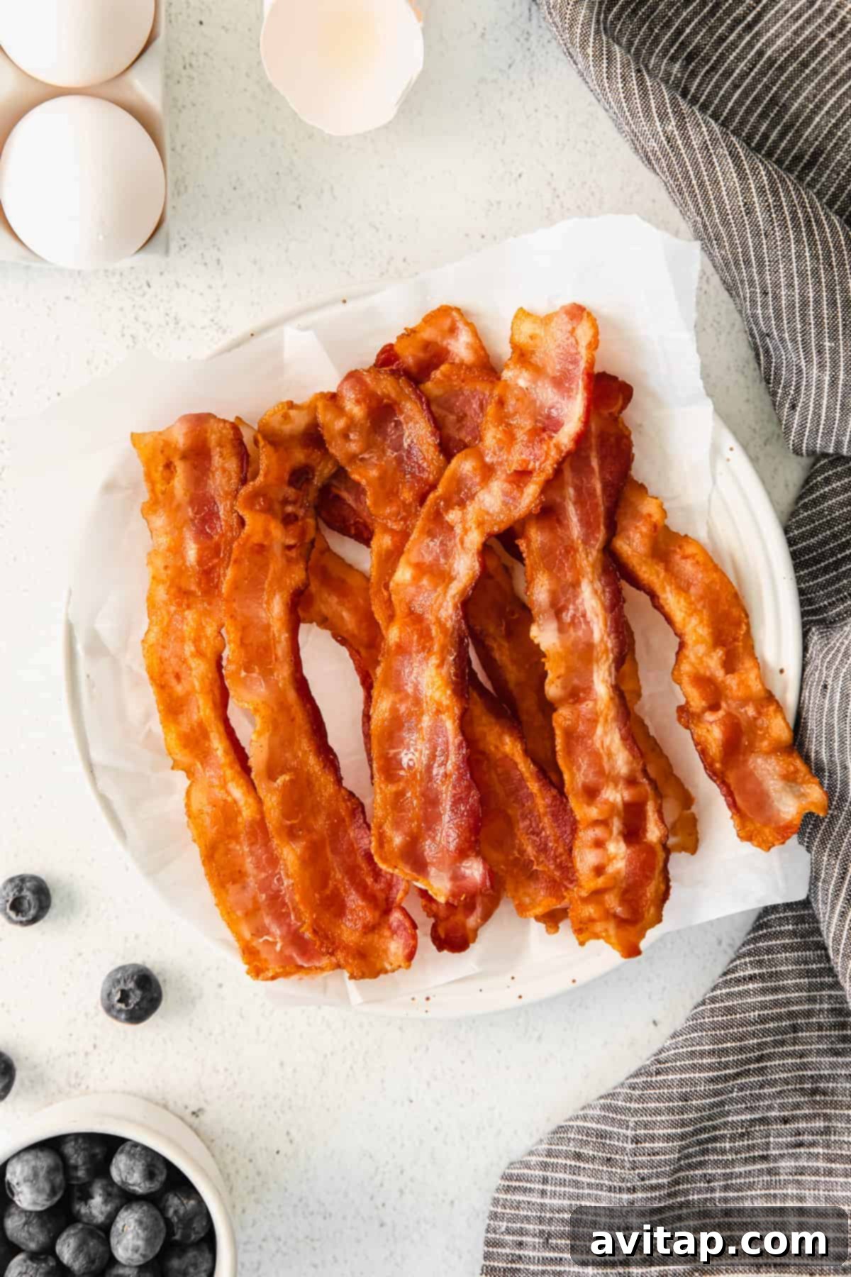 Perfectly cooked crispy bacon slices arranged on a plate