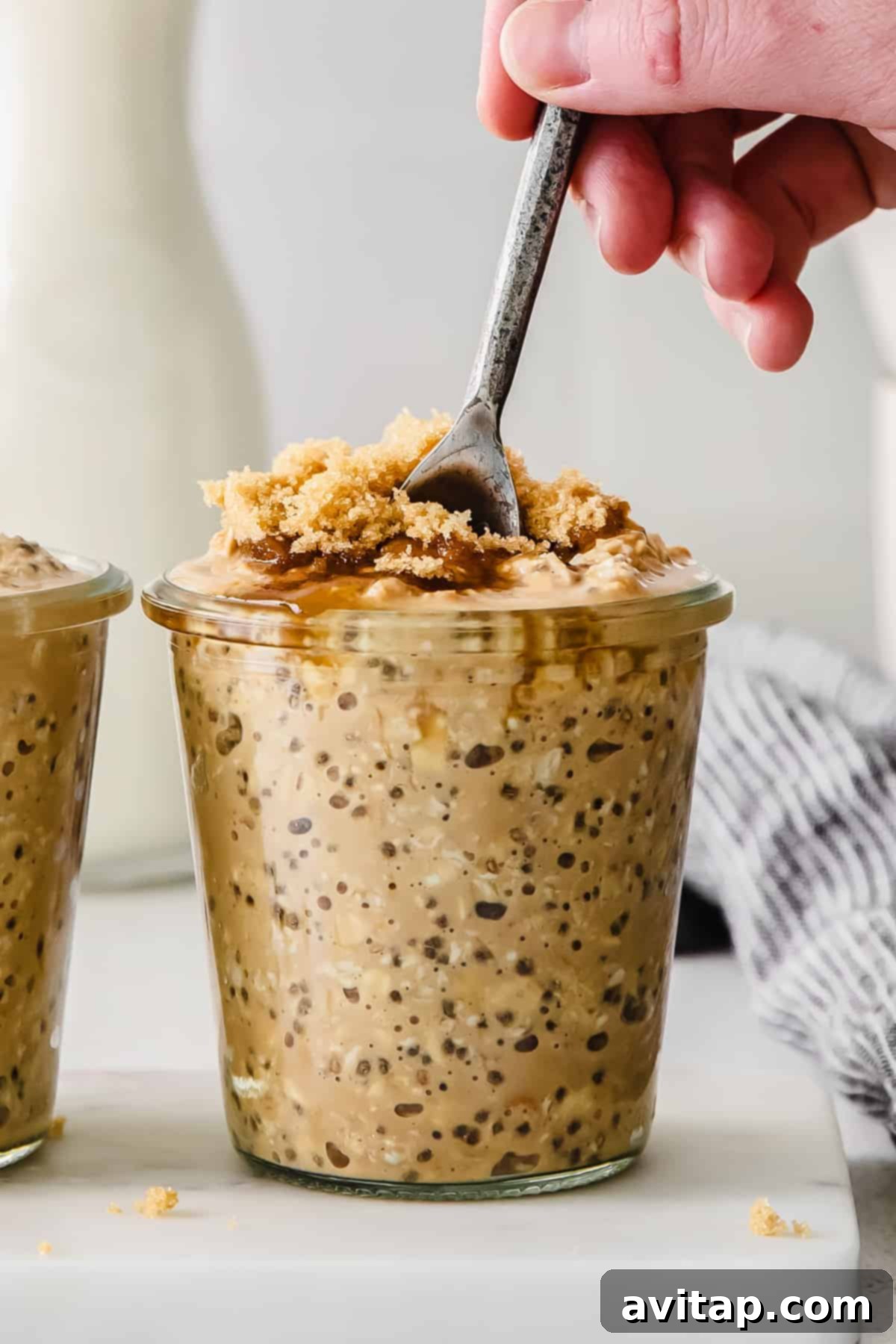 A perfectly prepared jar of brown sugar shaken espresso overnight oats with a spoon.