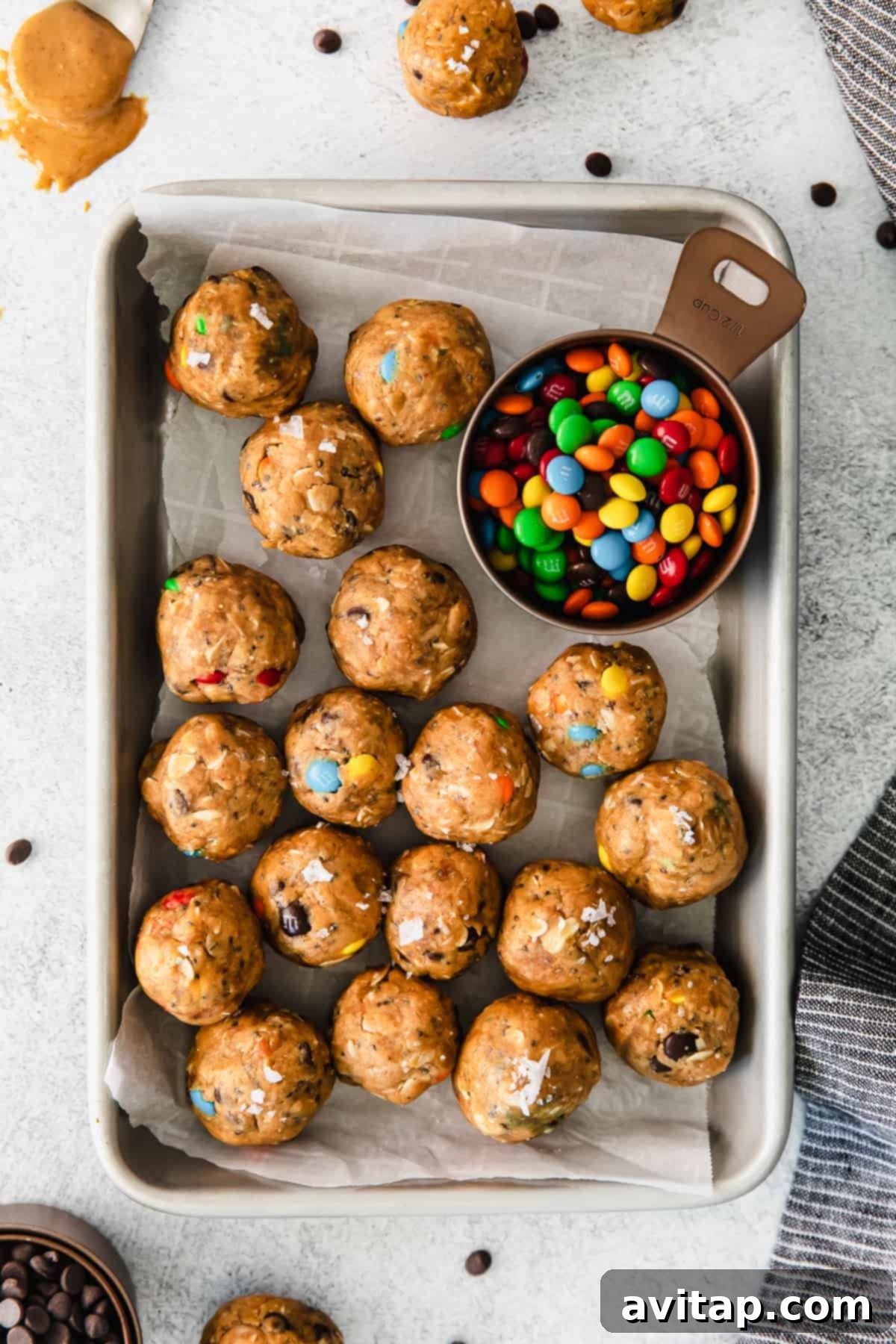 Freshly made monster cookie protein balls stored neatly in a clear container.