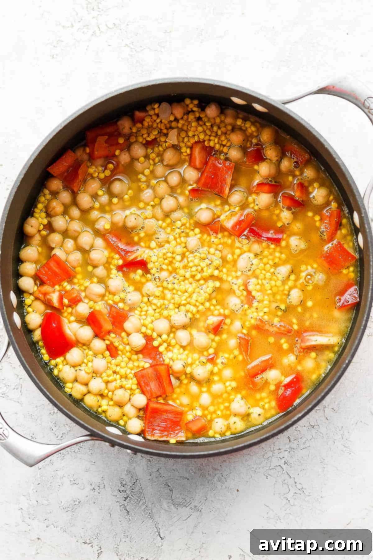 A completed one-pot Lemon Garlic Israeli Couscous dish, perfectly cooked and ready to be topped with pickled vegetables and whipped feta.