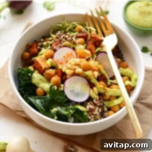 A buddha bowl recipe featuring quinoa and kale salad with a gold fork.