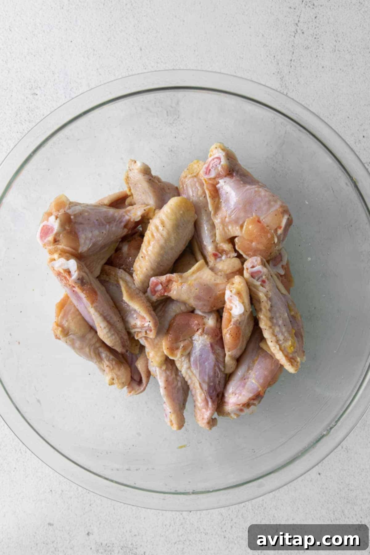Raw chicken wings in bowl.