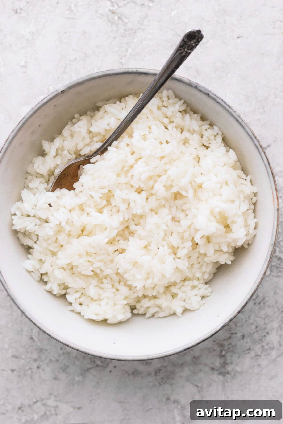 Sticky rice is a very versatile recipe to pair with many Asian-inspired dishes. Make sticky rice in your own kitchen with our step by step instructions. Enjoy! A bowl of perfectly cooked sticky rice, ready to be served, with a spoon nestled within the grains.