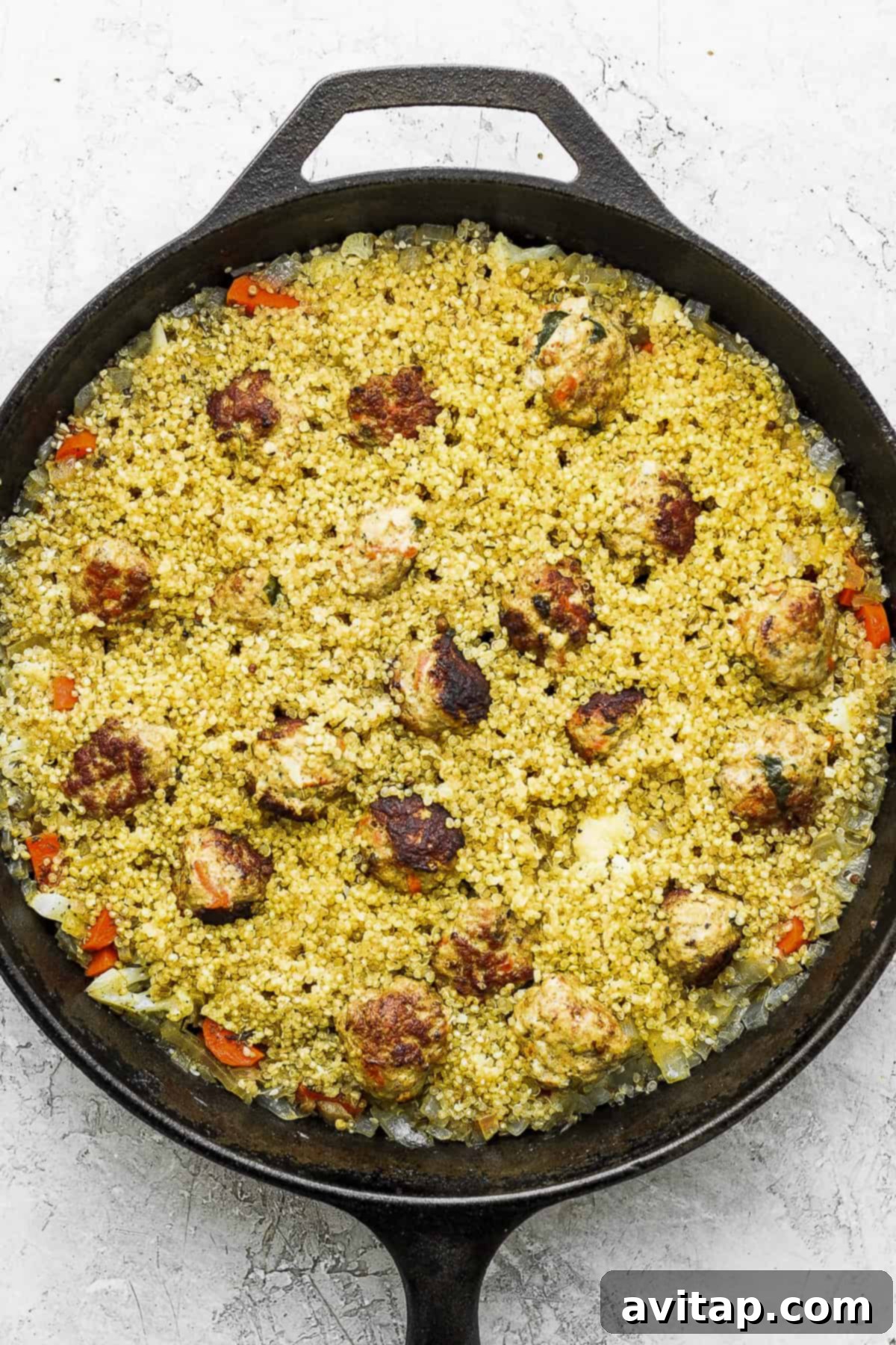 One-Pot Za'atar Meatballs and Quinoa, glistening in a cast iron skillet, ready for its yogurt topping.