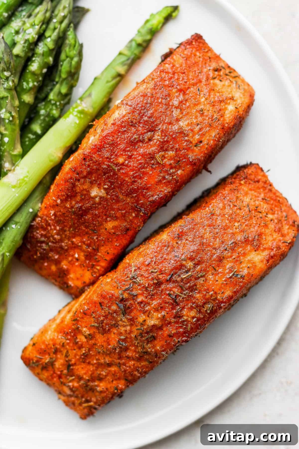 Perfectly cooked salmon fillet on a plate, showcasing its crispy skin and flaky texture.