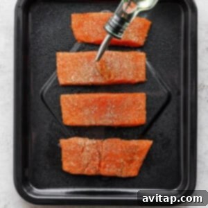 Salmon fillets arranged in an air fryer basket.