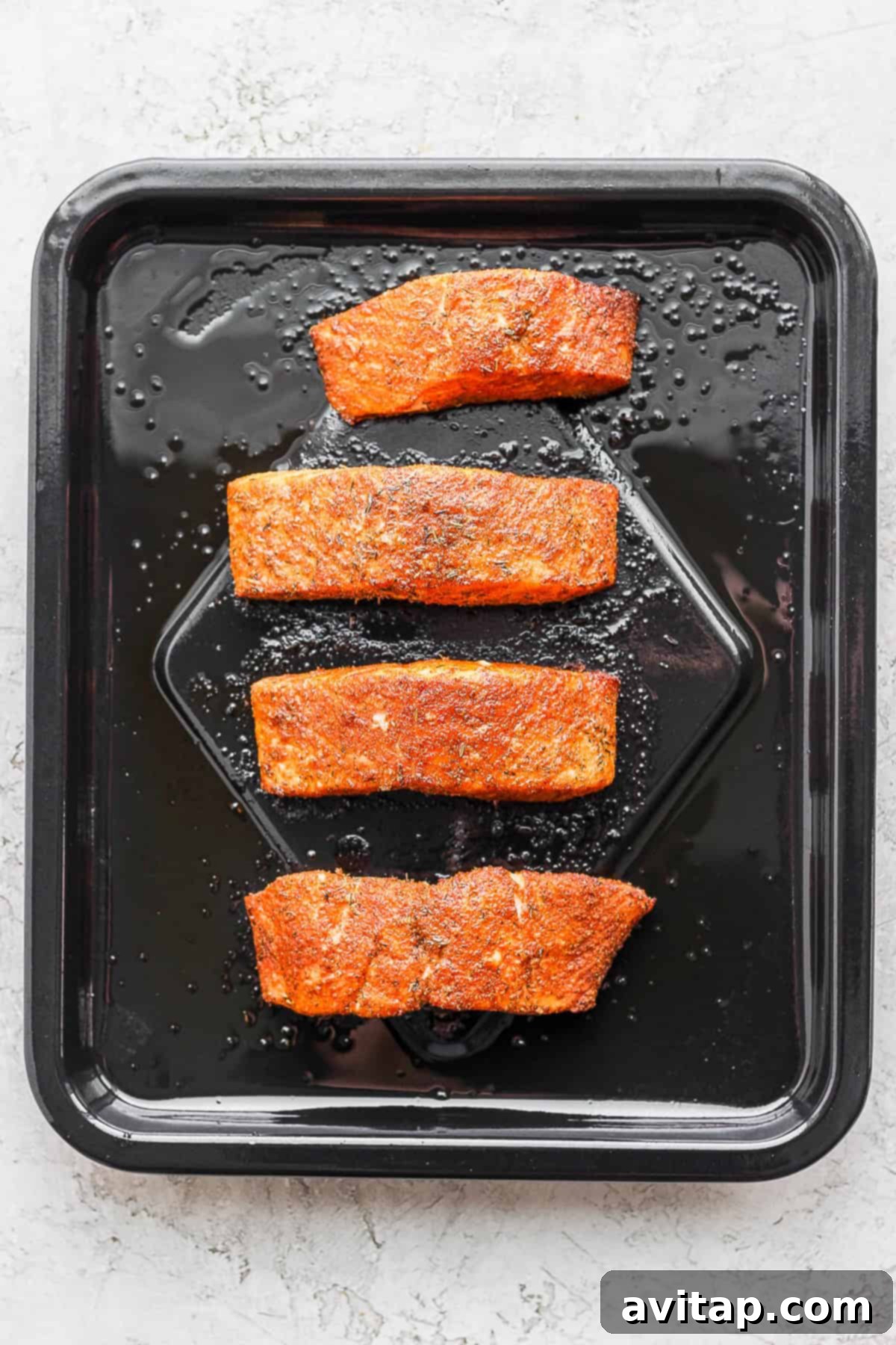 Salmon fillet placed skin-side down in an air fryer basket, ready for cooking.