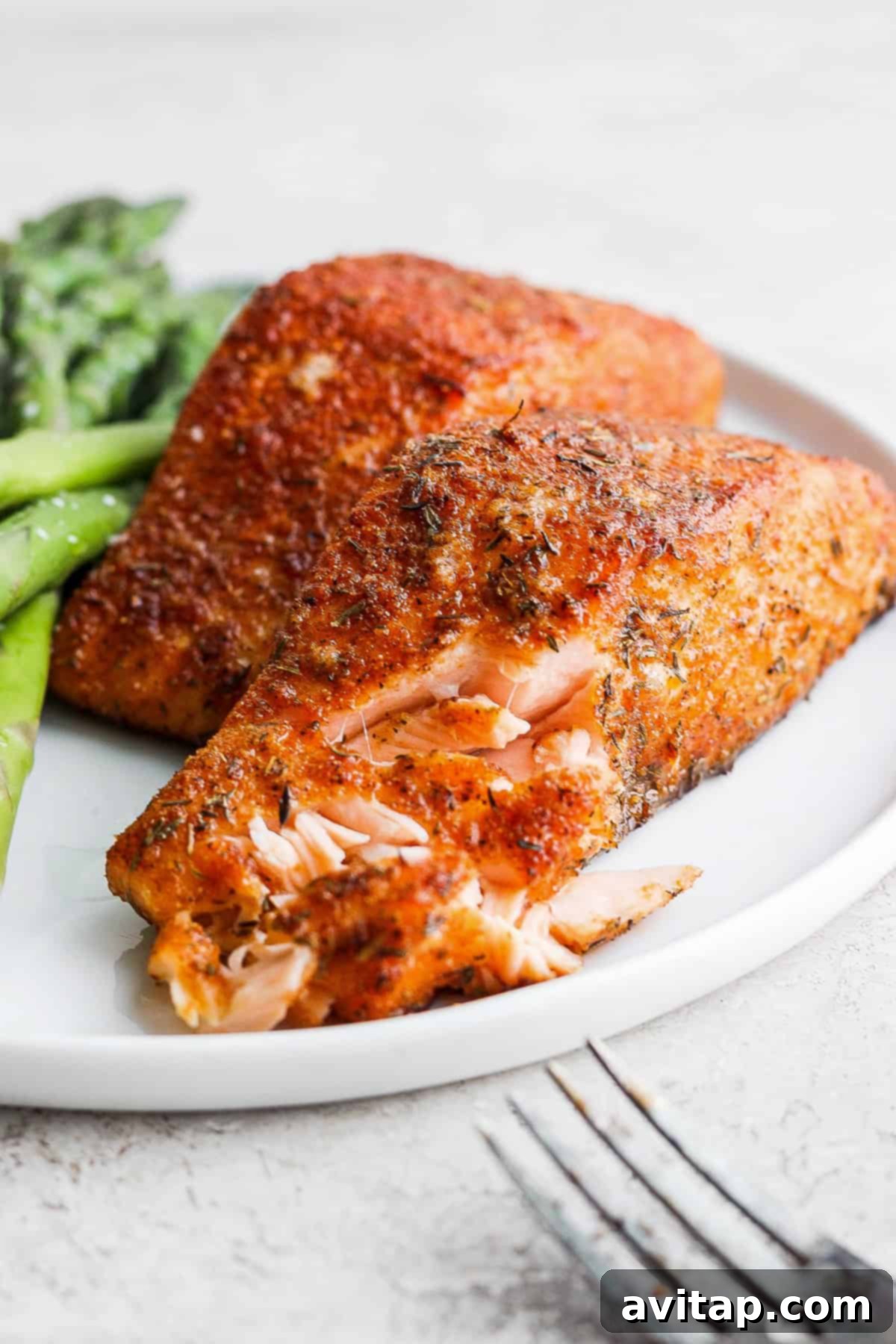 Close-up of flaky salmon on a plate, showcasing its tender texture.