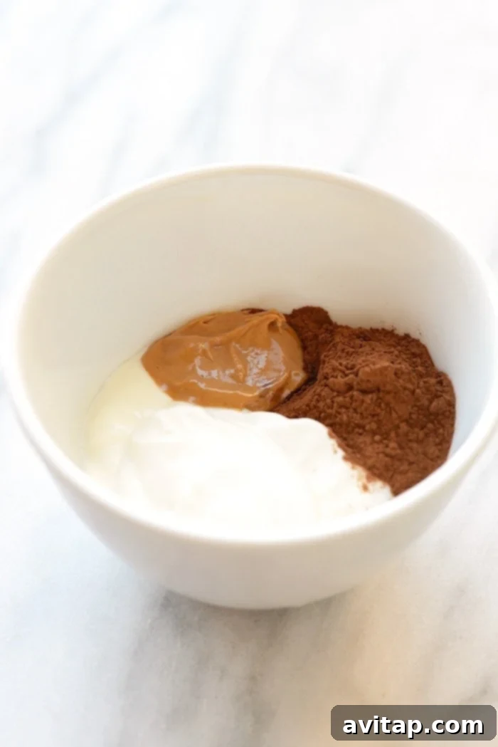 Mixing Mousse Ingredients Mixing the three ingredients for healthy chocolate peanut butter mousse in a bowl, showing the creamy texture forming