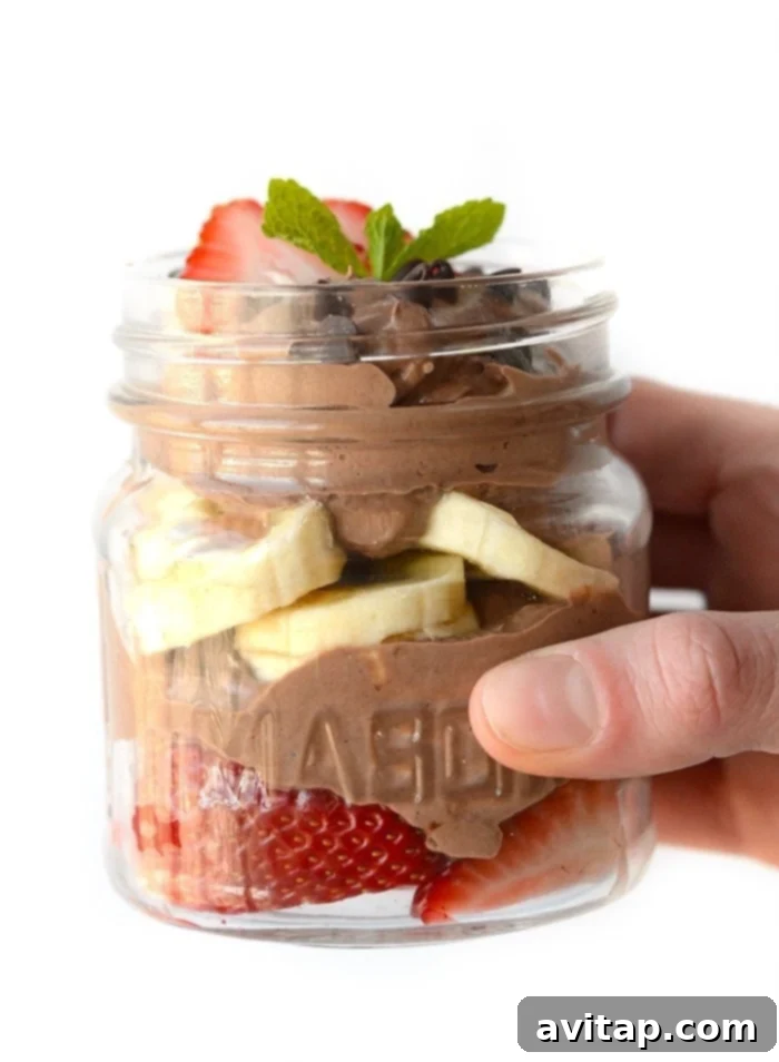 Fruity Mousse Parfait Healthy chocolate peanut butter mousse as a parfait with generous slices of fresh strawberries and bananas, showing vibrant color