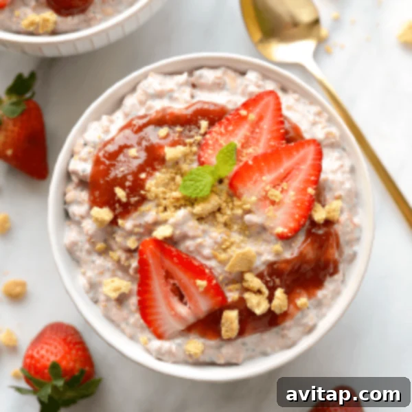 Two bowls of creamy strawberry overnight oats, garnished with fresh strawberries and granola, ready to eat.