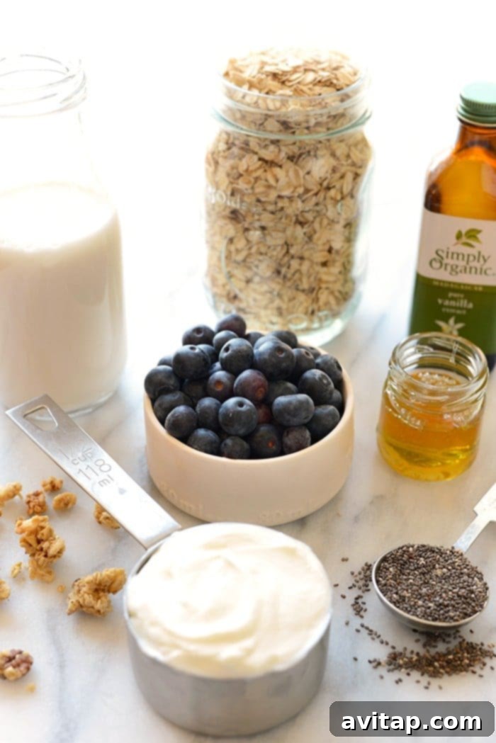Fresh ingredients like blueberries, Greek yogurt, honey, almond milk, and chia seeds come together for this delicious recipe! A selection of fresh ingredients laid out for making overnight oats: blueberries, oats, almond milk, Greek yogurt, honey, vanilla, chia seeds, and a lemon.