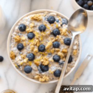 Overnight Blueberry Bliss 2 A close-up of a bowl of blueberry overnight oats, garnished with fresh blueberries and a spoon.