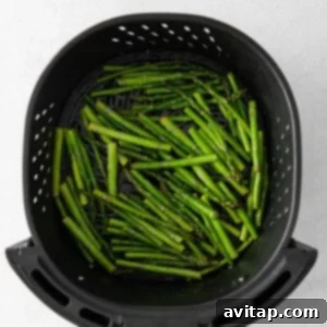 Crispy Air Fryer Asparagus 10 Asparagus arranged in an air fryer basket.