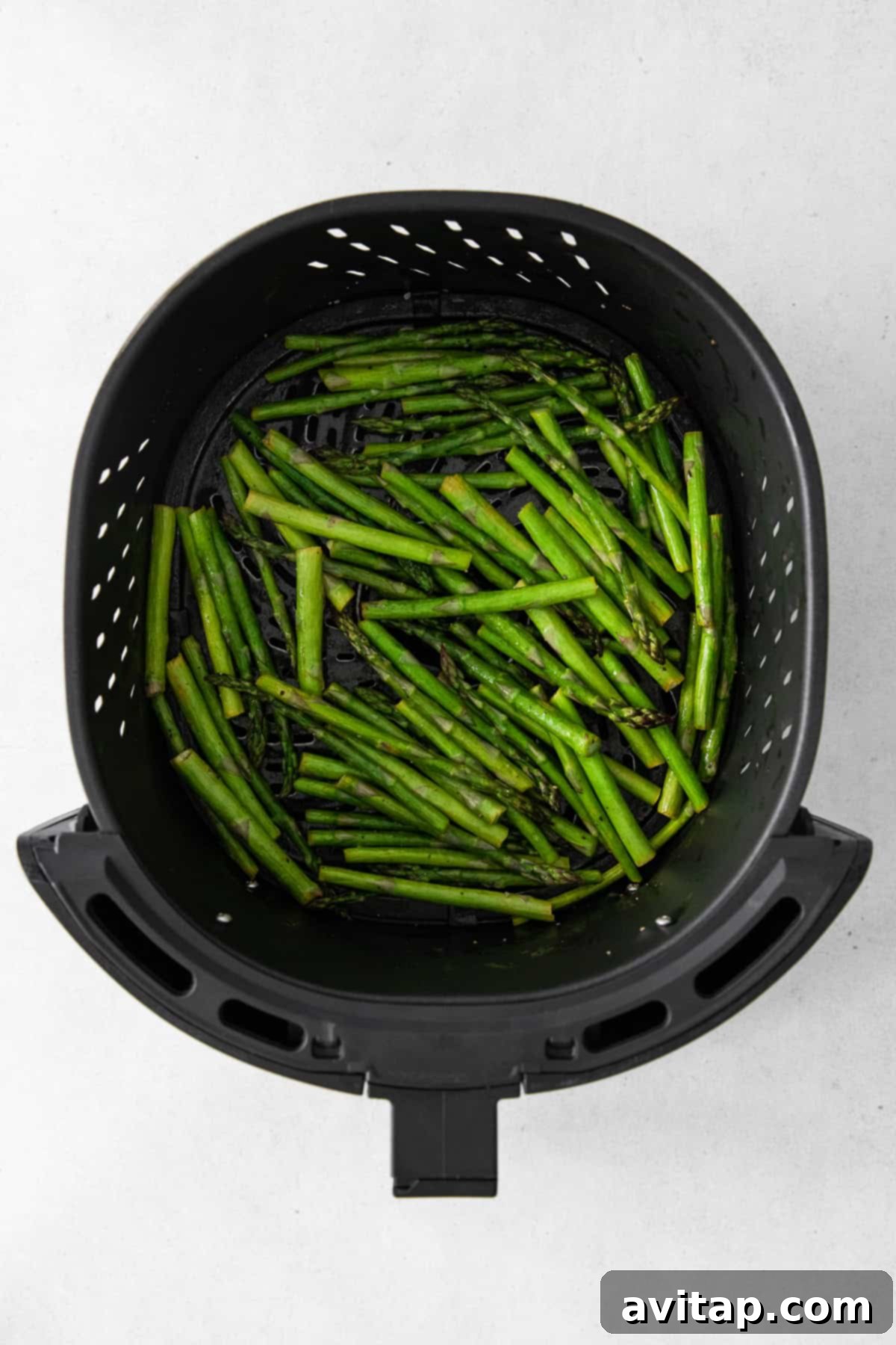 Freshly trimmed asparagus spears neatly arranged on a cutting board, ready for cooking.
