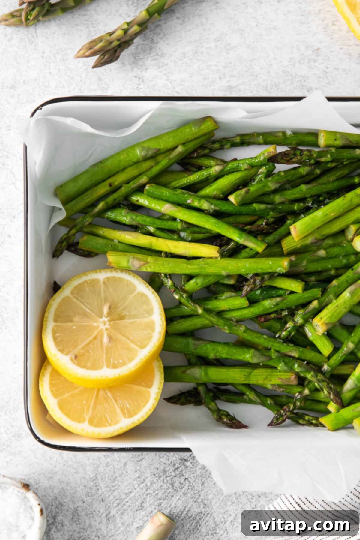A vibrant platter of crispy air fryer asparagus, glistening with lemon and olive oil, ready for serving.