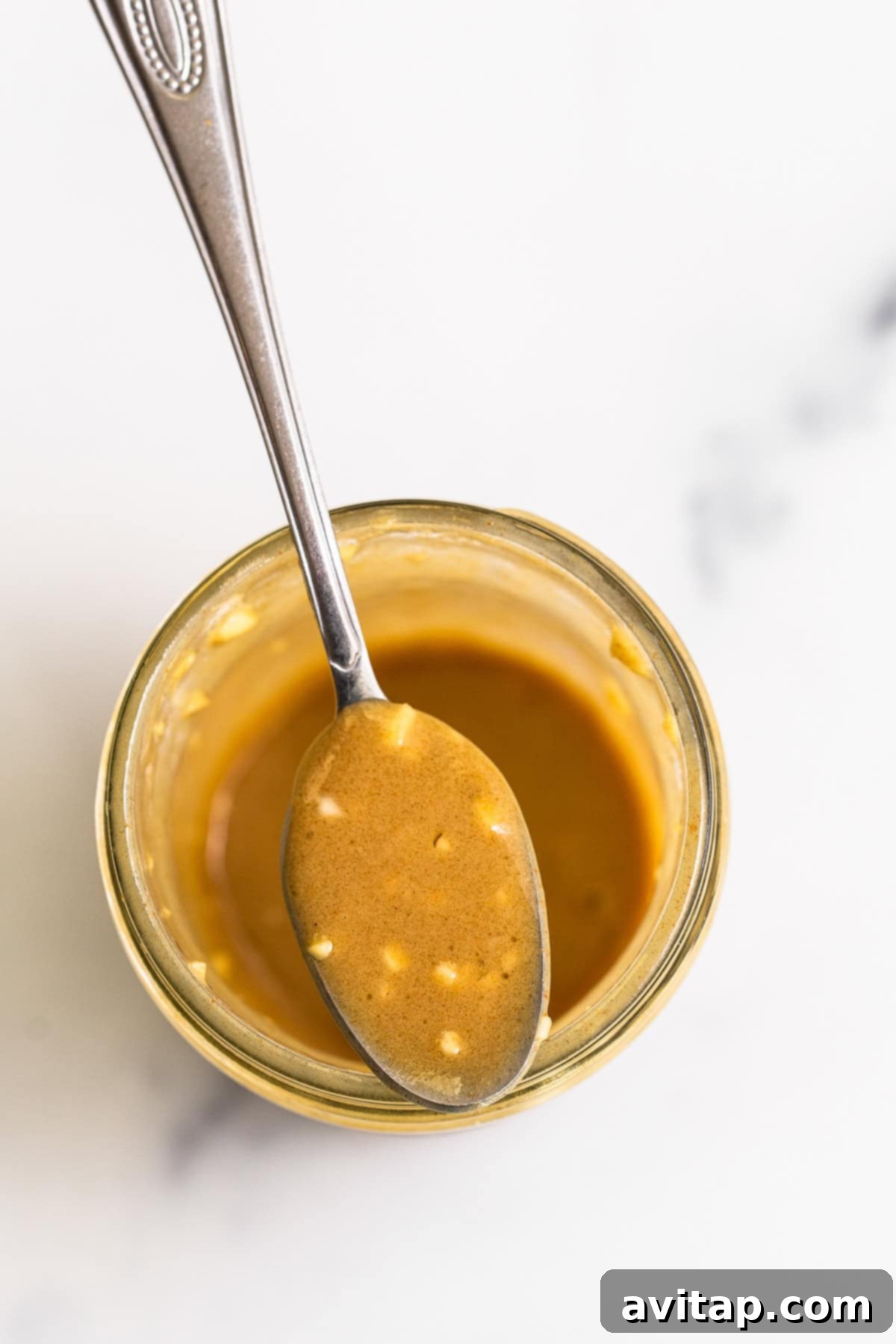 Homemade honey mustard dressing in a mason jar, perfectly emulsified for French Carrot Salad.