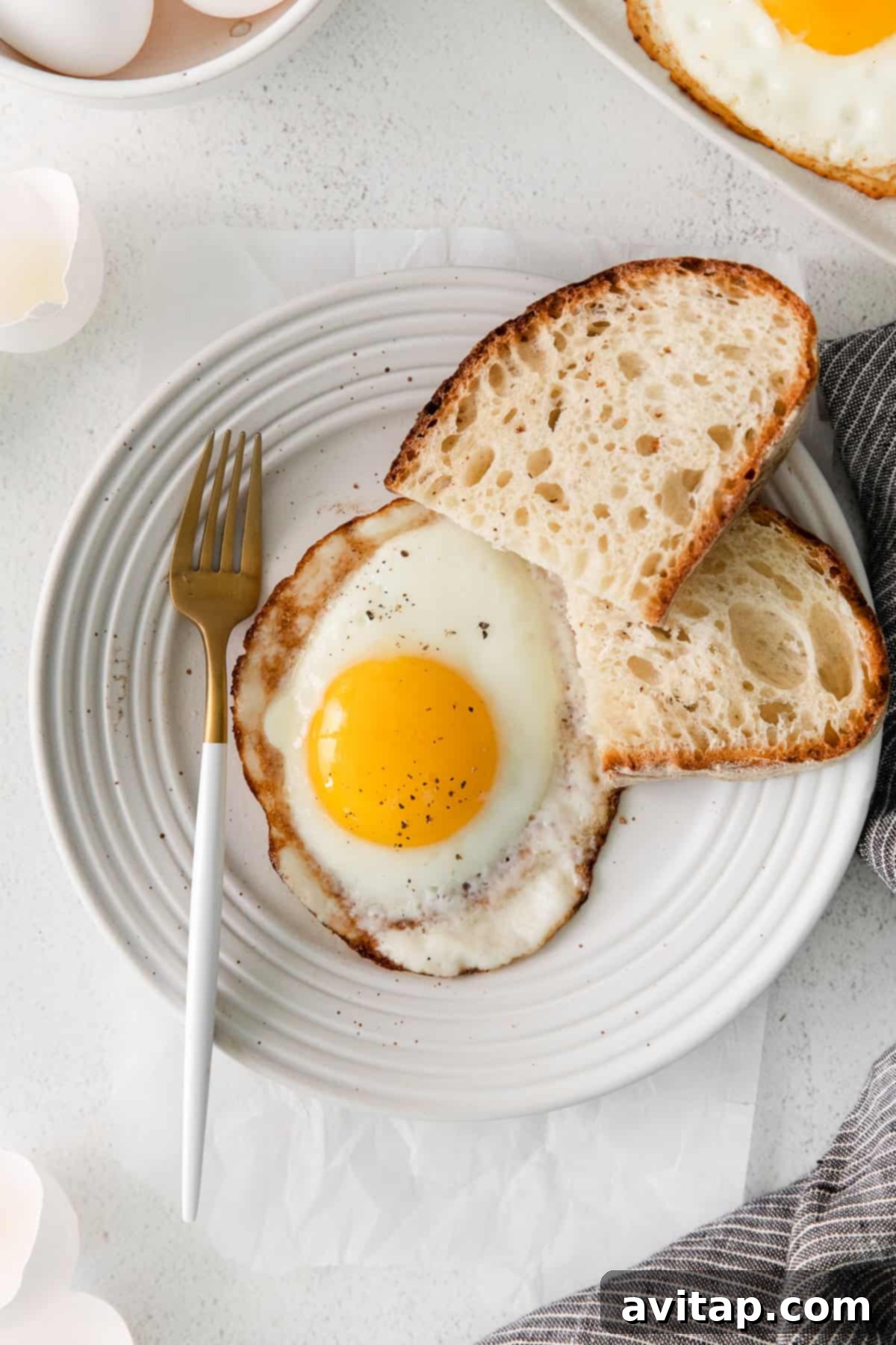 A perfectly fried over-easy egg glistening on a plate, ready to be served.