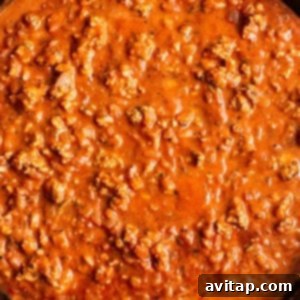 A skillet filled with ground turkey meat and rich red sauce simmering.
