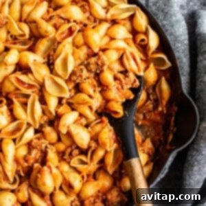 A skillet filled with pasta and ground turkey meat sauce mixed together.