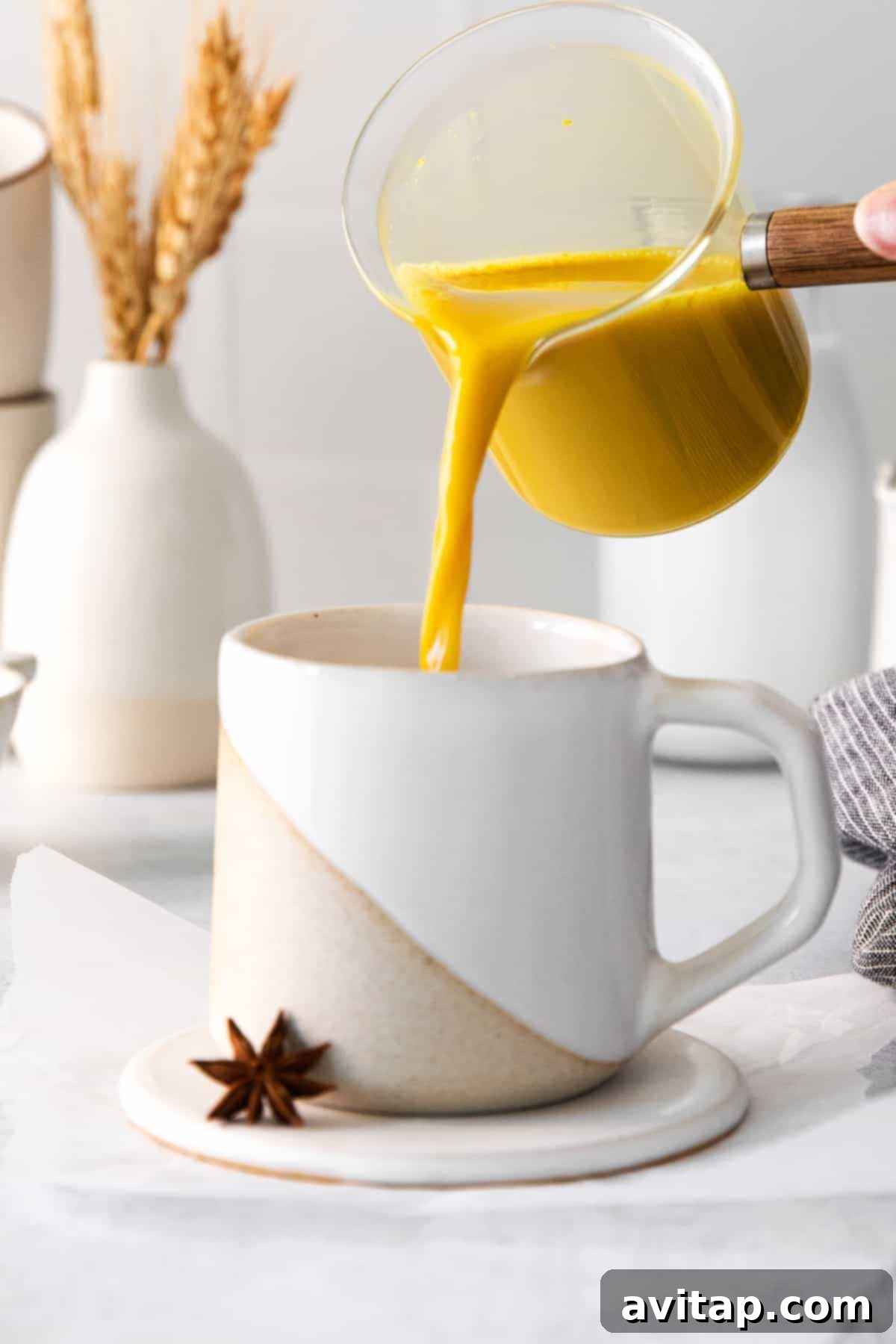 Pouring golden milk latte into a glass