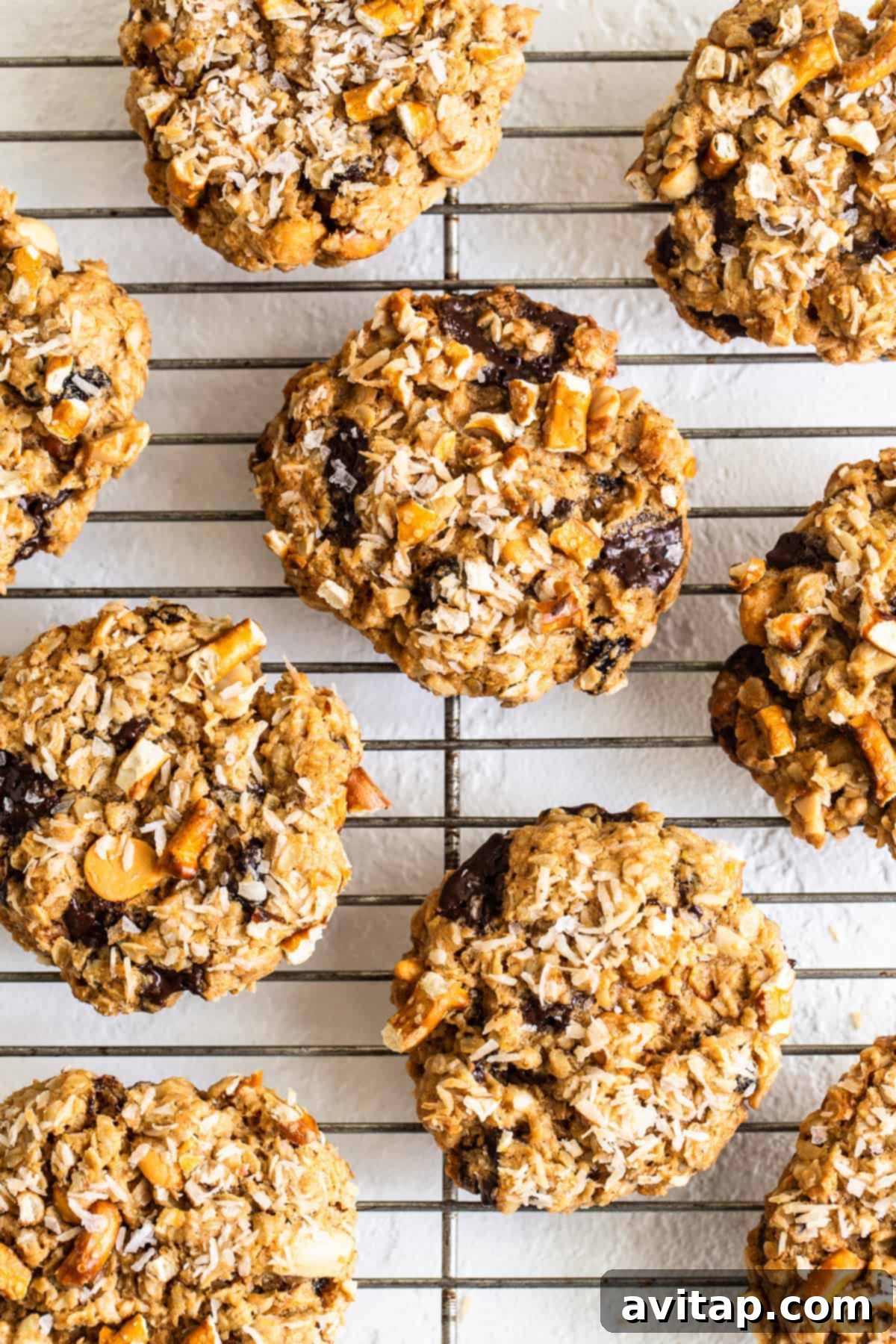 Freshly baked kitchen sink cookies cooling on a wire rack, showcasing their varied textures and delicious add-ins.