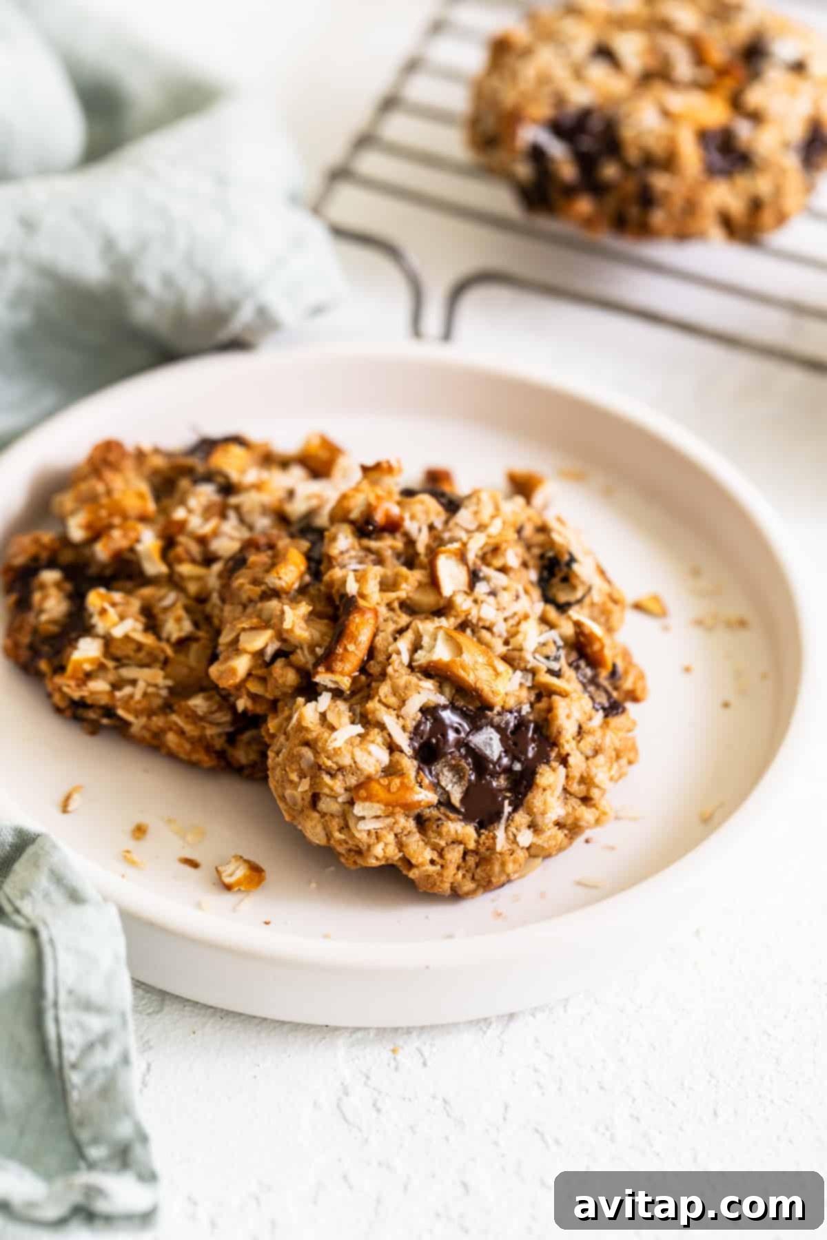 A plate stacked with several golden-brown kitchen sink cookies, showcasing their inviting texture and generous mix-ins.