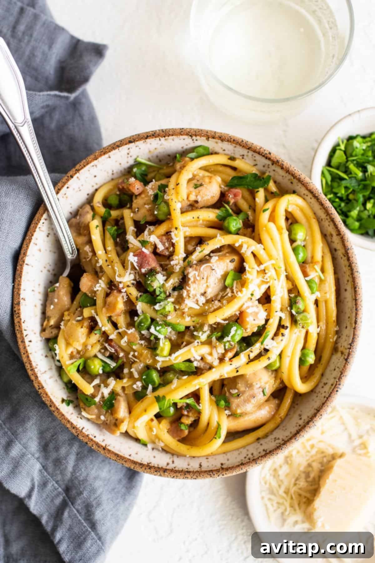 Delicious Chicken carbonara served in a bowl with a spoon, ready to eat.
