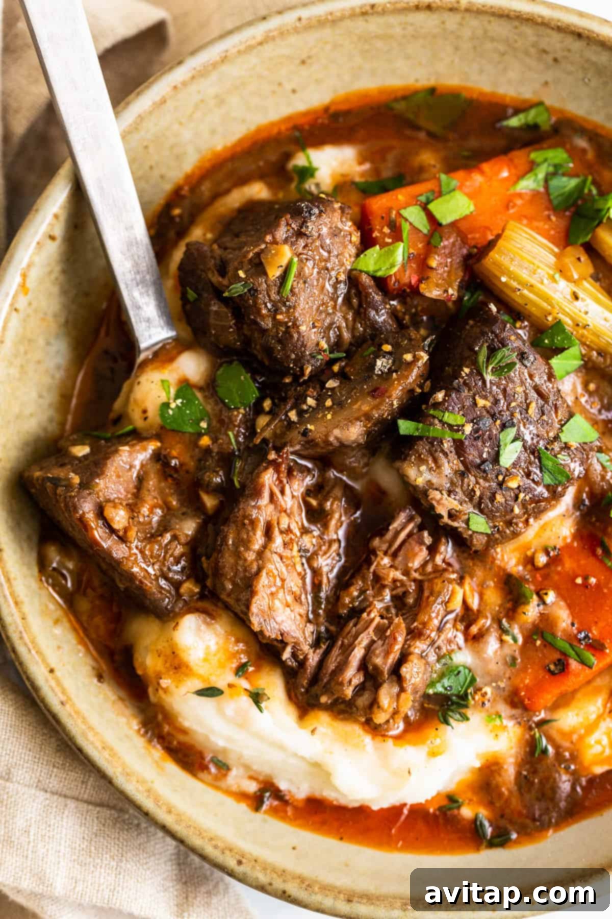 Hearty beef stew served generously over a bed of creamy mashed potatoes.