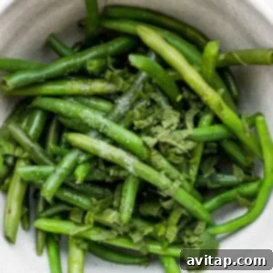 Blanched green beans with mint in a bowl.