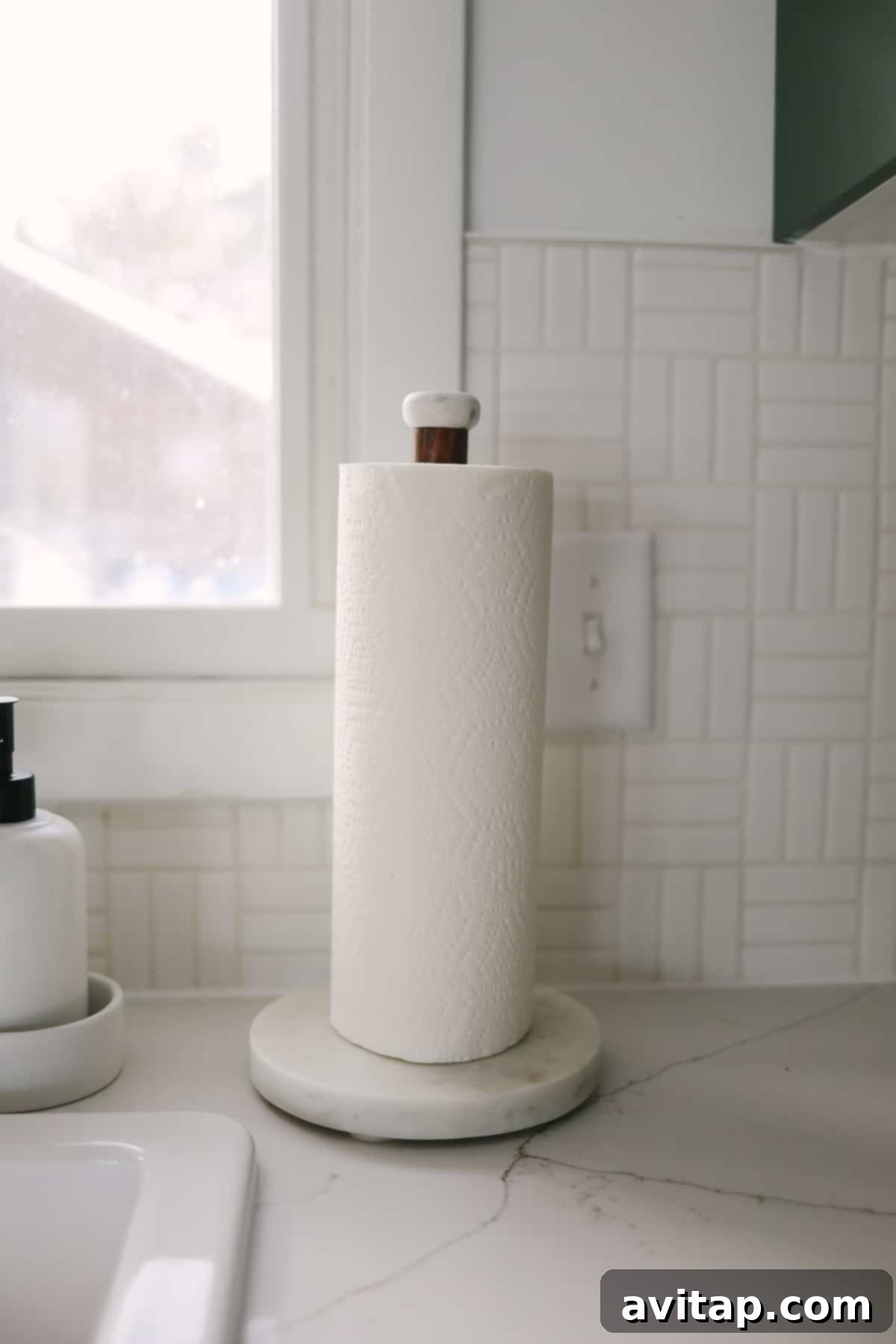 Close-up of the elegant lattice weave tile backsplash in light grey grout, paired with a modern paper towel holder.