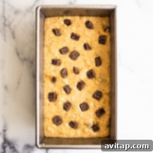 Banana bread batter with chocolate chips in a baking pan, ready for the oven.