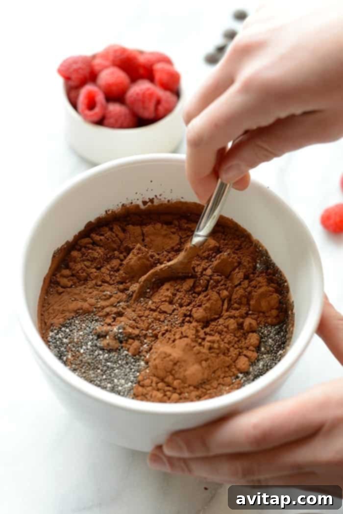 Chocolate chia seed pudding ingredients being stirred up in a bowl