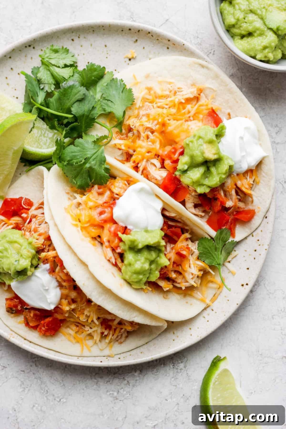 Flavorful Crockpot Chicken Tacos on a plate, garnished and ready to serve.