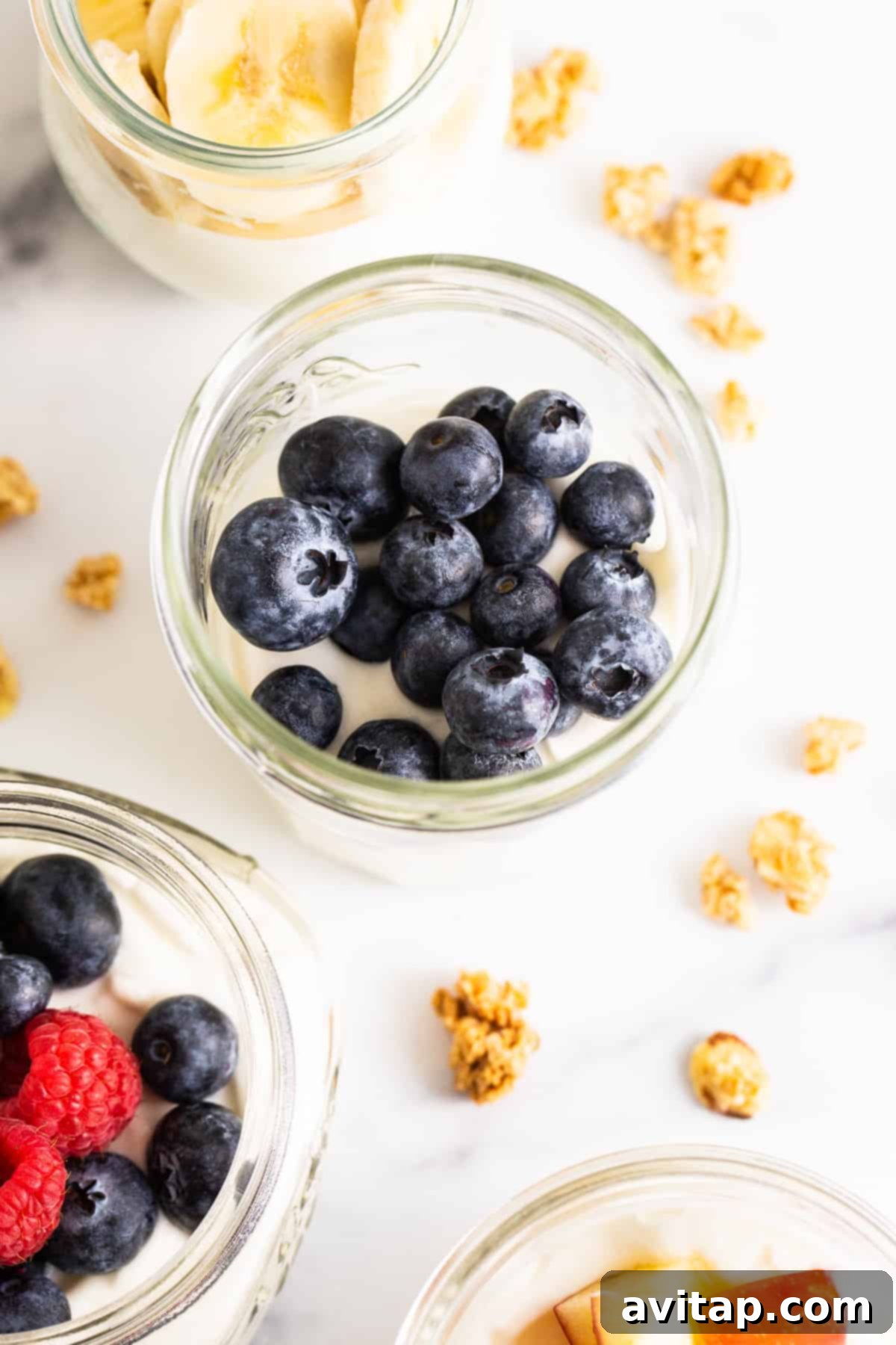 Close-up of fresh blueberries being layered into a yogurt parfait