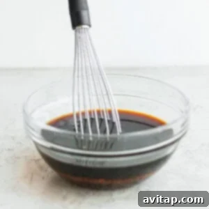 A whisk in a bowl with a sauce.