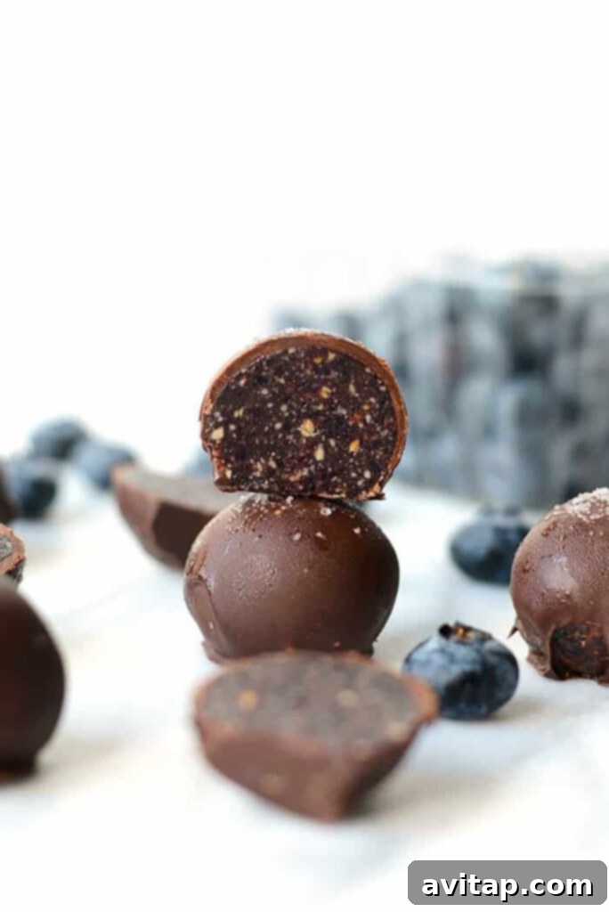 Blueberry truffles arranged artfully on a pristine white surface, showcasing their delicious dark chocolate coating.
