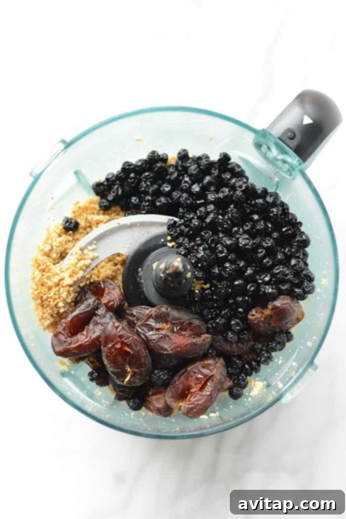 A close-up shot of several dark chocolate dipped blueberry cashew truffles, garnished with a sprinkle of sea salt, inviting a delicious clean eating treat.