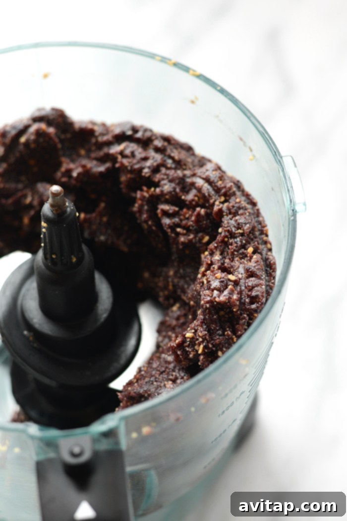 A beautiful display of clean eating blueberry truffles, featuring dried fruit and a luscious dark chocolate coating, presented as a sweet and healthy treat.