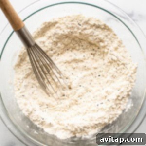 The dry ingredients for lemon poppy seed bread in a bowl, showing the flour, poppy seeds, and lemon zest.