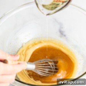 Adding sunflower oil slowly to the wet ingredients mixture (egg and brown sugar) while whisking.