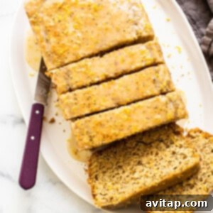 A freshly sliced loaf of lemon poppy seed bread on a plate, ready for serving.