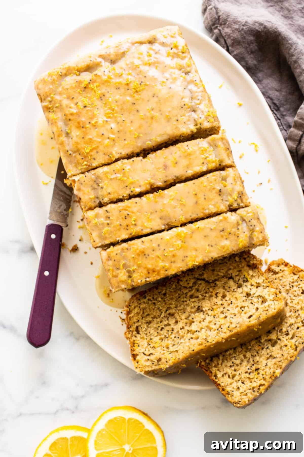 A beautifully sliced loaf of lemon poppy seed bread on a serving plate, ready to be enjoyed.