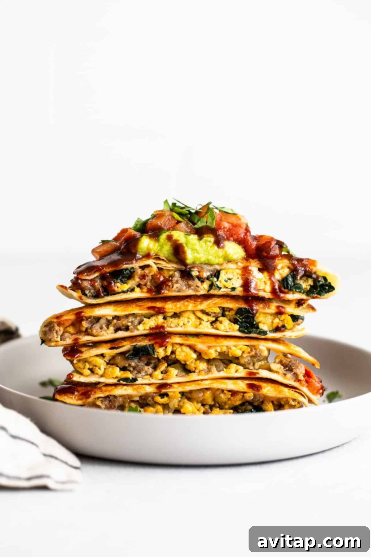 Stack of ready-to-eat make-ahead breakfast quesadillas. A tempting stack of golden-brown breakfast quesadilla halves, ready to be devoured.